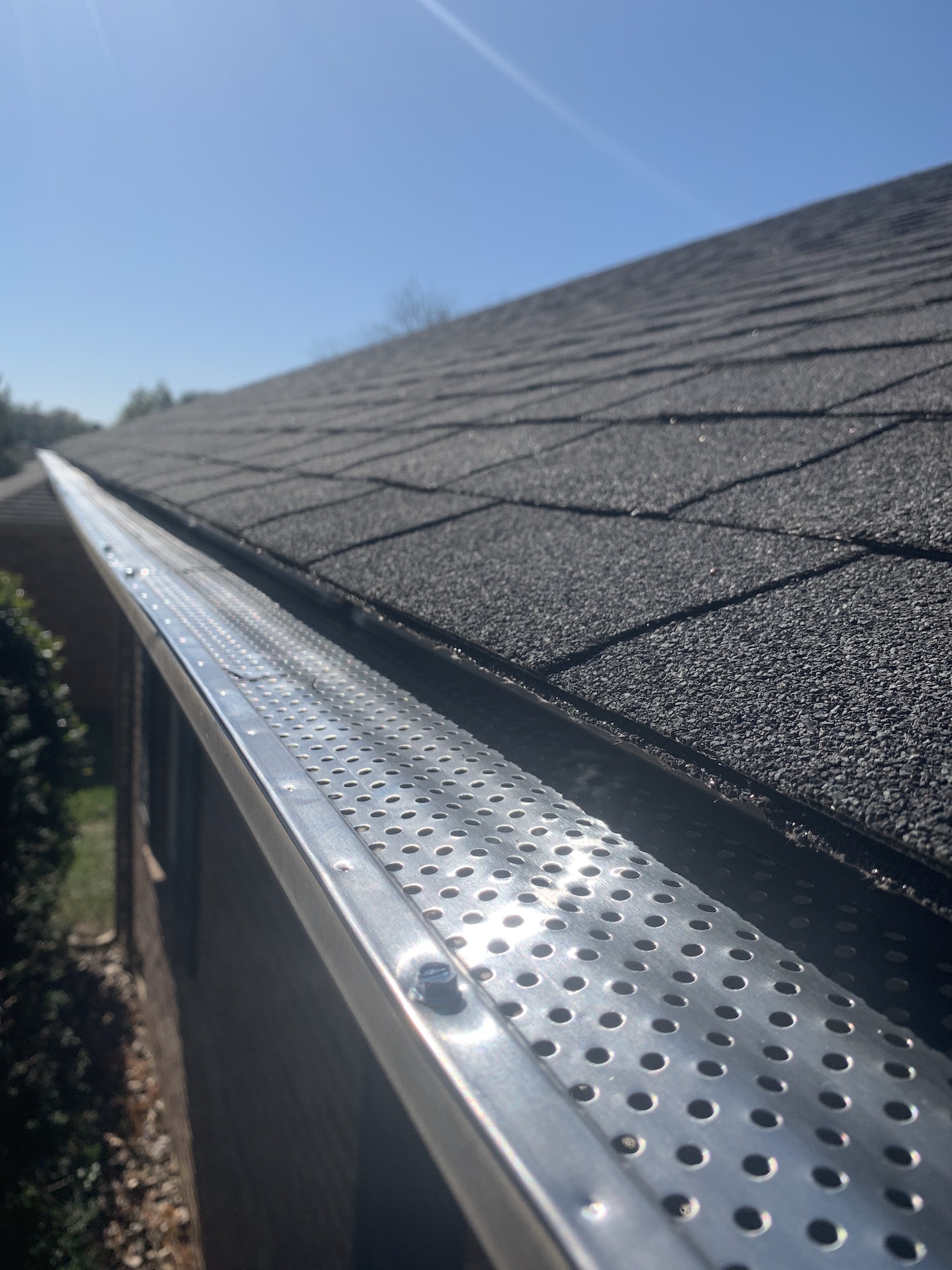Roof of a house showing gutter and gutter guard protection against leaves Home maintenance